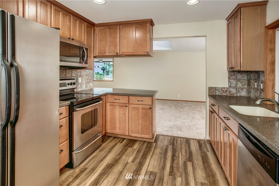 14437 157th Place Southeast Renton, WA 98059 - Photo 6 of 18 a kitchen with a sink stove and refrigerator