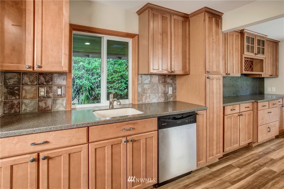 14437 157th Place Southeast Renton, WA 98059 - Photo 7 of 18 a kitchen with granite countertop a sink a stove and cabinets