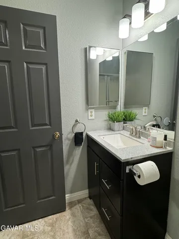 a bathroom with a granite countertop sink and a mirror