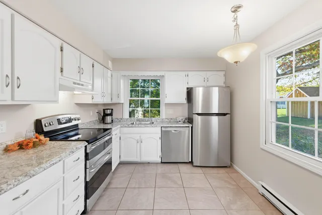 a kitchen with white cabinets and appliances