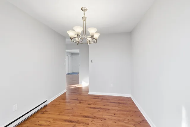 a view of a room with wooden floor and chandelier
