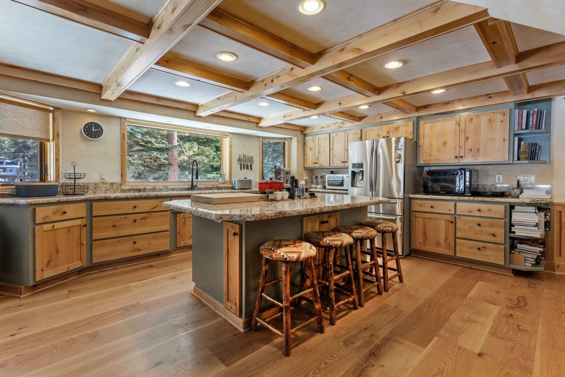 6442 Donner Road Tahoe Vista, CA 96148 - Photo 7 of 28 a kitchen with stainless steel appliances kitchen island granite countertop a sink cabinets and wooden floor
