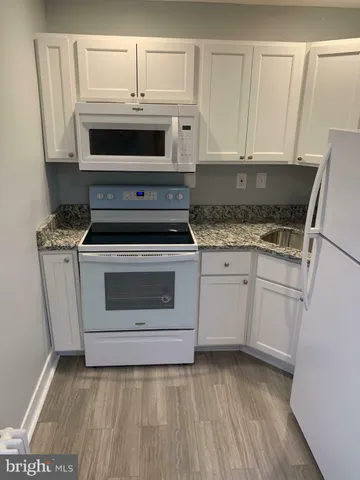 a kitchen with appliances a sink and cabinets