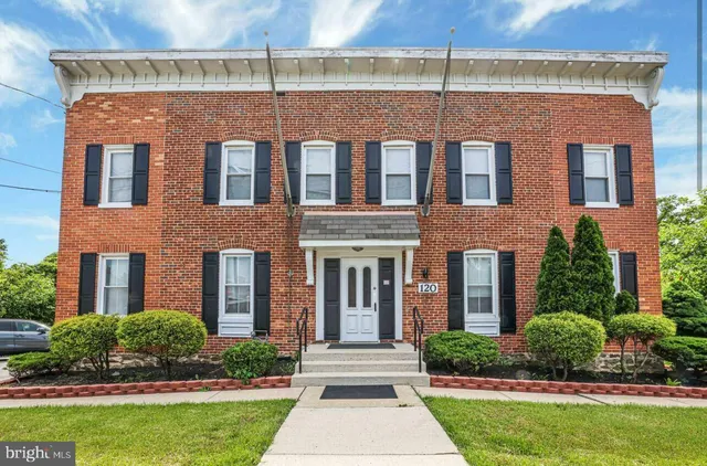 front view of a brick house with a yard