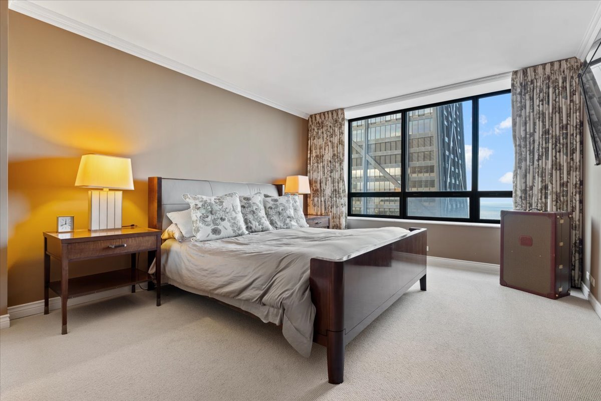 180 East Pearson Street, Unit 4002 Chicago, IL 60611 - Photo 25 of 40 a spacious bedroom with a bed and a large window