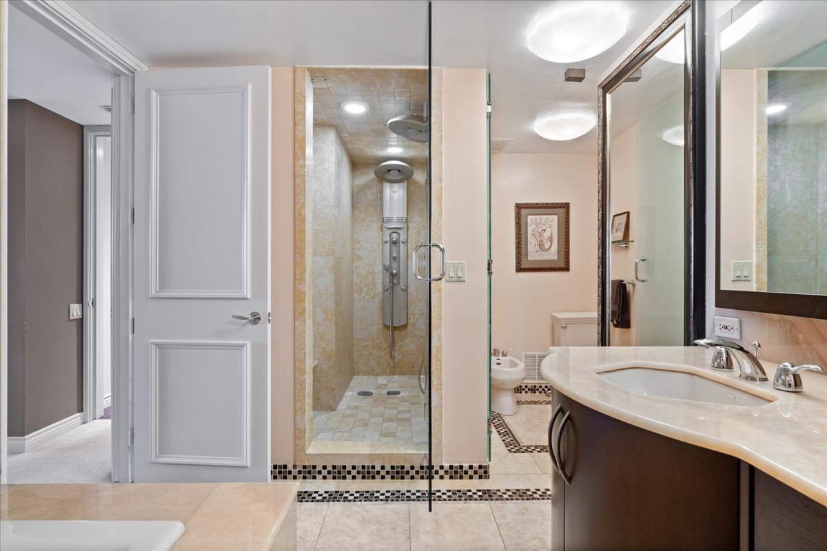 180 East Pearson Street, Unit 4002 Chicago, IL 60611 - Photo 29 of 40 a bathroom with a granite countertop sink mirror and shower