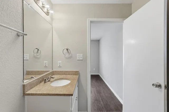 a bathroom with a sink and mirror with toilet
