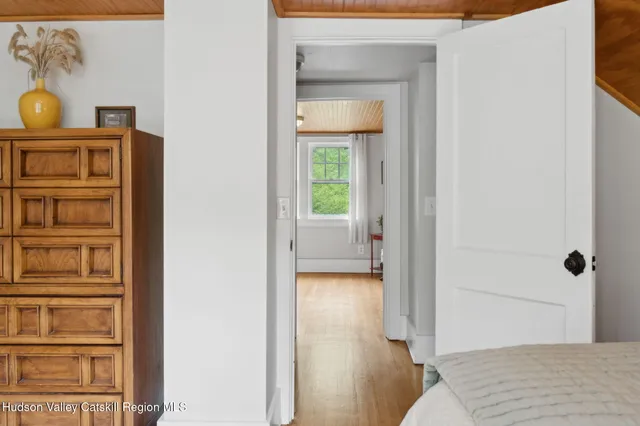 a view of a hallway with wooden floor and dining room