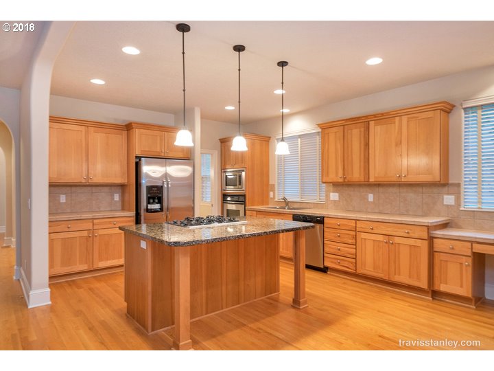 4636 Northwest Corazon Terrace Portland, OR 97229 - Photo 6 of 18 a kitchen with stainless steel appliances kitchen island granite countertop a sink and cabinets