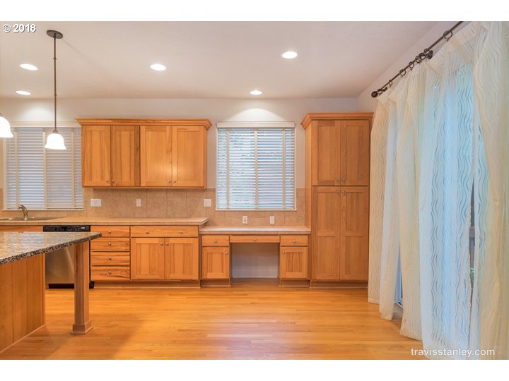 4636 Northwest Corazon Terrace Portland, OR 97229 - Photo 7 of 18 a kitchen with stainless steel appliances granite countertop a sink and a refrigerator