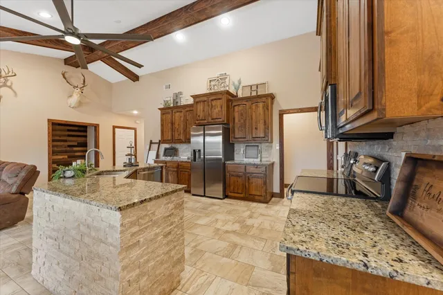 a kitchen with stainless steel appliances granite countertop a sink stove and refrigerator