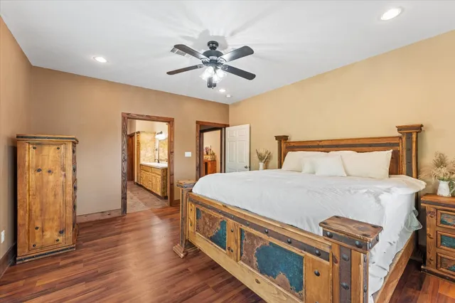 a large bedroom with a bed and wooden floor