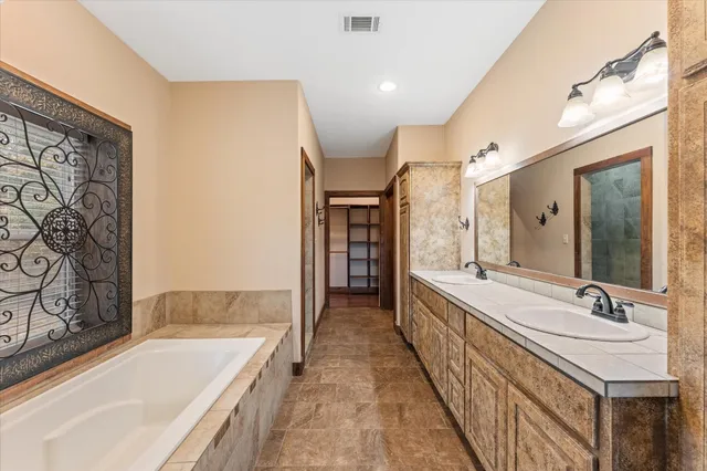 a bathroom with a granite countertop sink and a bathtub