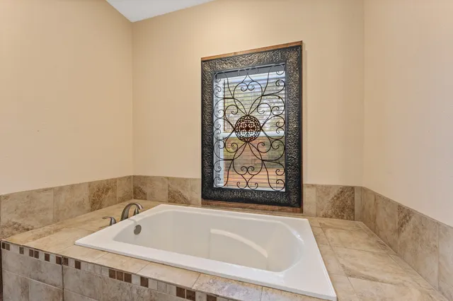 a bathroom with bathtub and window