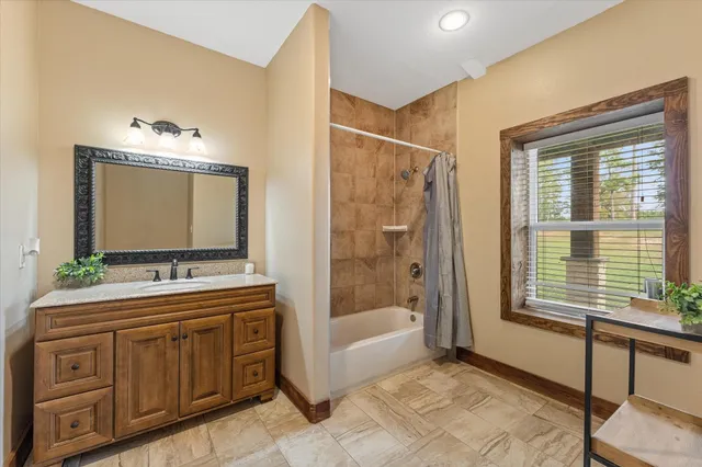 a bathroom with a tub sink and mirror