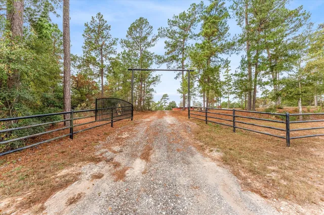 a view of a yard with wooden fence