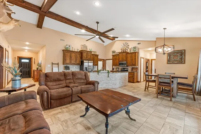 a living room with lots of furniture and a dining table with wooden floor