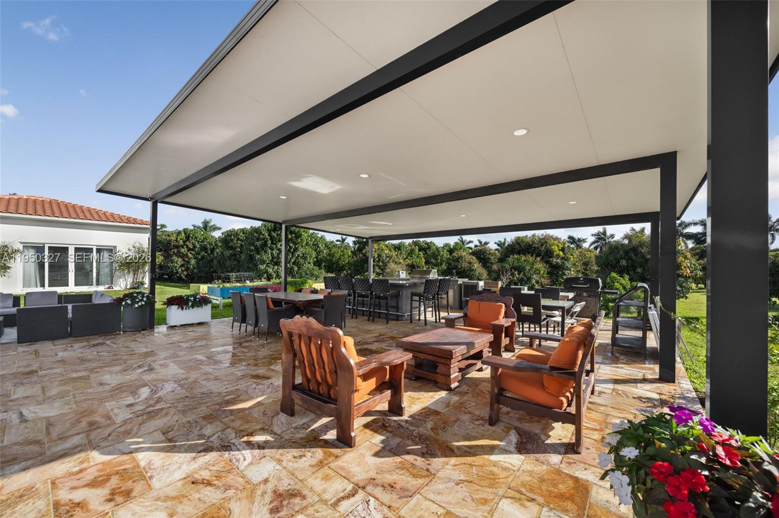 34650 Southwest 218th Avenue Homestead, FL 33034 - Photo 41 of 52 a view of a patio with table and chairs potted plants with floor to ceiling window