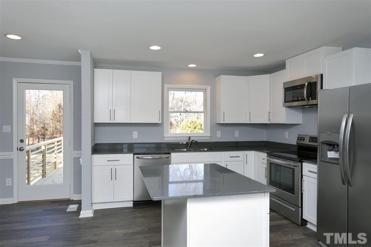 2016 Howson Road Raleigh, NC 27603 - Photo 11 of 25 a kitchen with stainless steel appliances granite countertop a stove a sink a refrigerator a microwave a refrigerator and cabinets