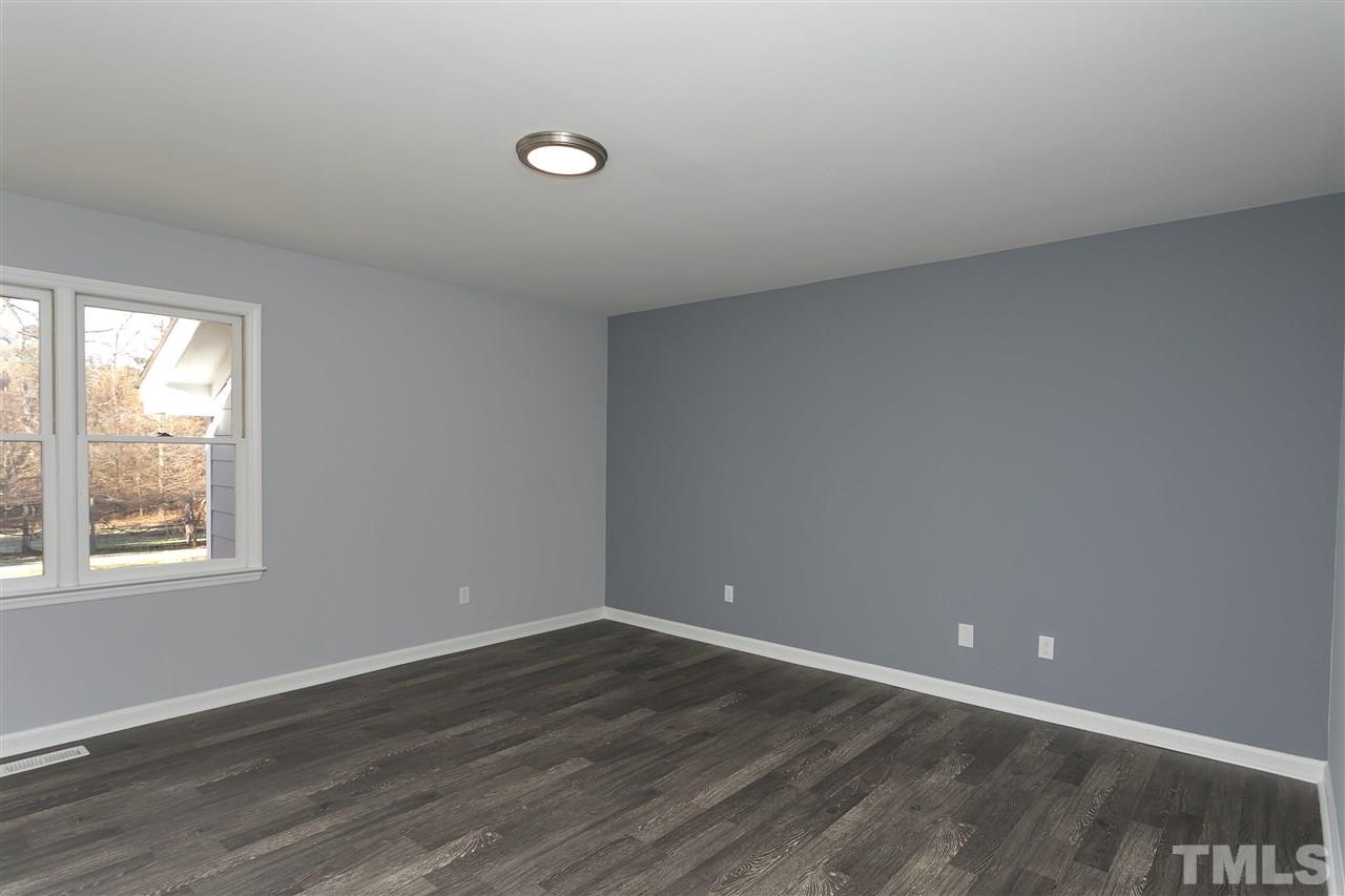 2016 Howson Road Raleigh, NC 27603 - Photo 14 of 25 an empty room with wooden floor and windows