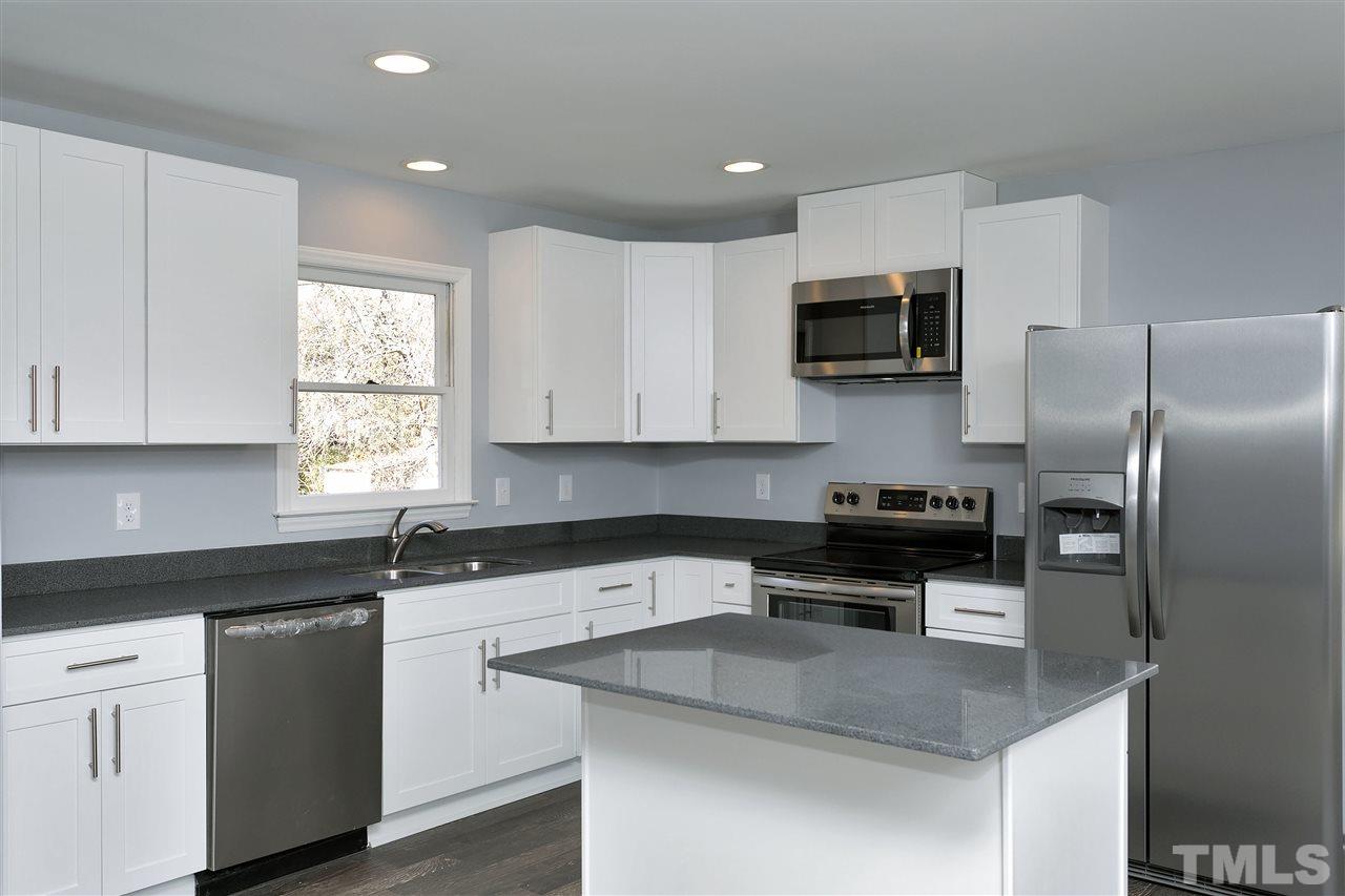 2016 Howson Road Raleigh, NC 27603 - Photo 10 of 25 a kitchen with a sink a microwave a refrigerator and cabinets