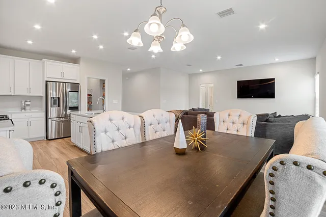 a large kitchen with a table chairs and a refrigerator