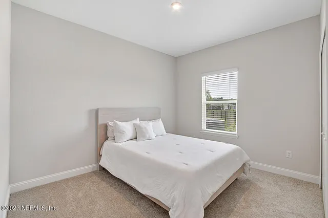 a bed sitting in a bedroom next to a window