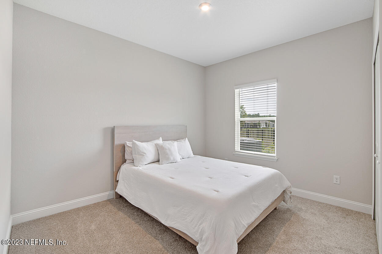 13186 Dunwick Road Jacksonville, FL 32256 - Photo 17 of 48 a bed sitting in a bedroom next to a window