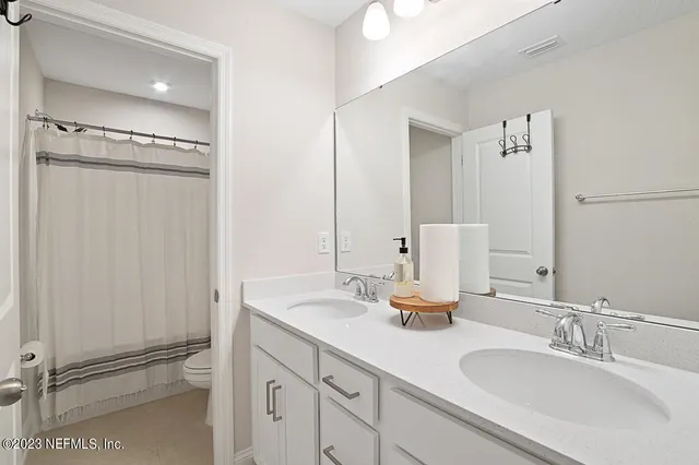 a en suite bathroom with a double vanity sink and mirror
