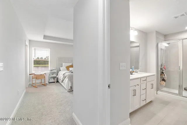 a bedroom with a bed and large windows