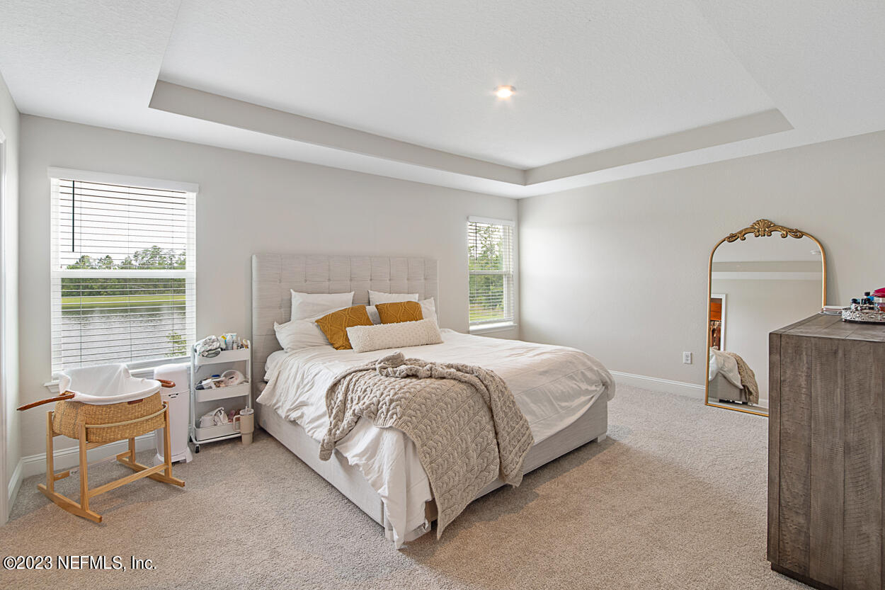 13186 Dunwick Road Jacksonville, FL 32256 - Photo 27 of 48 a bedroom with a bed and large windows