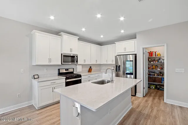 a kitchen with stainless steel appliances a refrigerator sink and cabinets