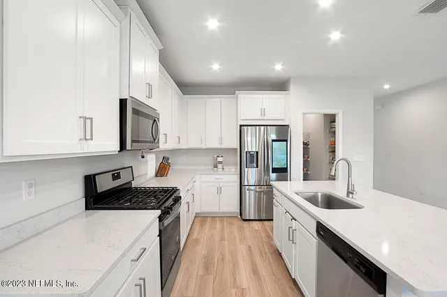 a kitchen with stainless steel appliances a refrigerator sink and microwave
