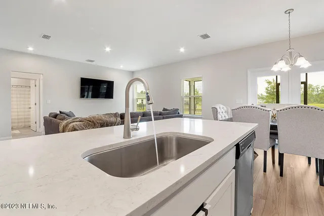 a kitchen with a dining table chairs and white cabinets