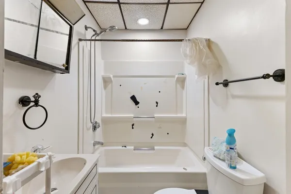 a bathroom with a granite countertop bathtub shower sink vanity and mirror