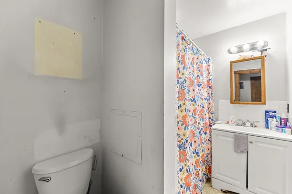 a bathroom with a sink a toilet and shower curtain