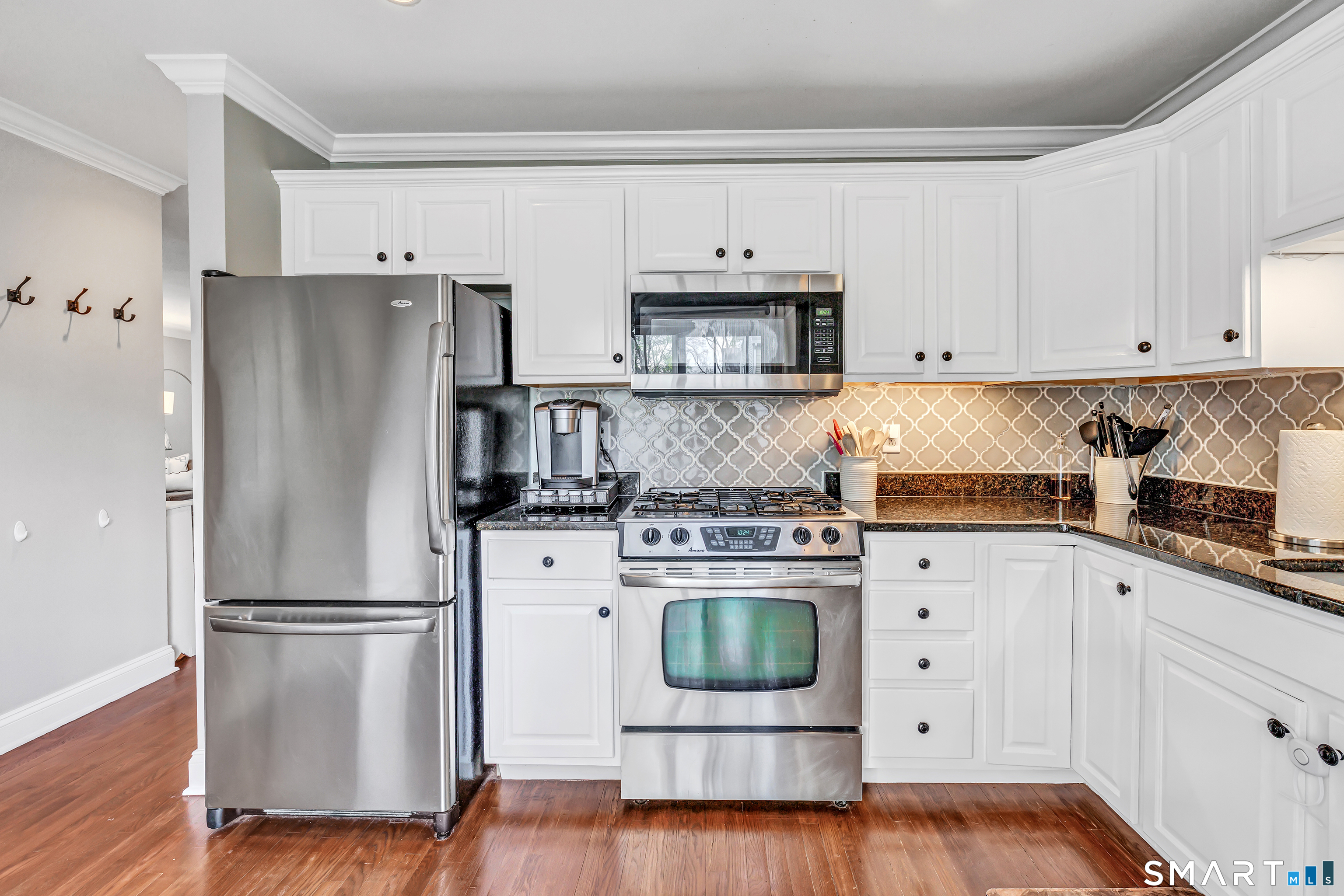 39 Maple Tree Avenue, Unit 15 Stamford, CT 06906 - Photo 8 of 32 a kitchen with white cabinets white stainless steel appliances and wooden floors