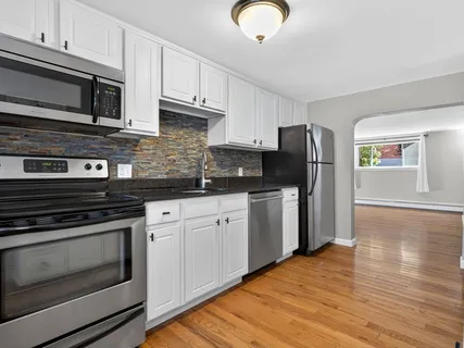 a kitchen with stainless steel appliances granite countertop a stove microwave and refrigerator