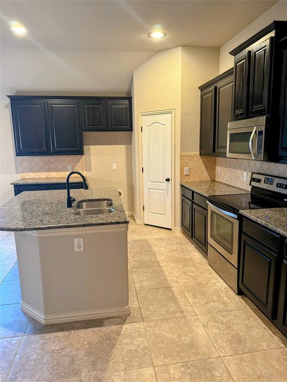 236 Archer Way Forney, TX 75126 - Photo 9 of 35 a kitchen with stainless steel appliances granite countertop a sink stove and refrigerator
