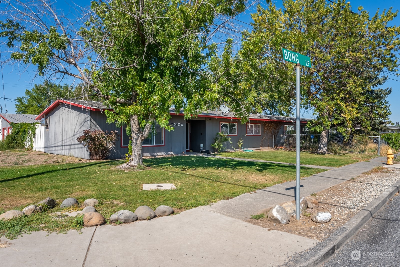 9015 Bong Loop, Unit 9017 Moses Lake, WA 98837 - Photo 25 of 26 a house with green field in front of it
