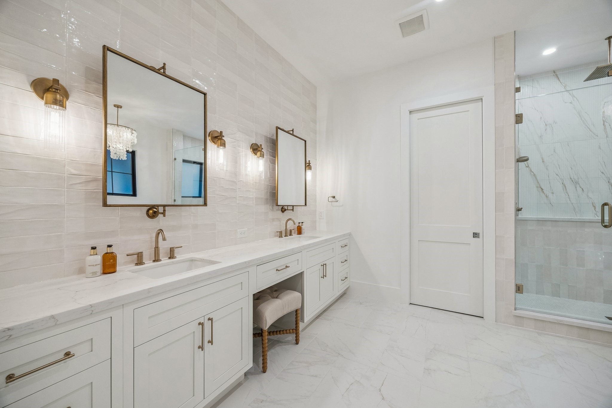 4034 Lanark Lane Houston, TX 77025 - Photo 18 of 32 Primary Bath with 12 x 24 Marble Dolomite White Tile Floor. Inset Shaker Style Cabinetry with Soft Close Drawers and Doors. Long Double Vanity with Slab Quartz Counter and a 3 x 9 Glazed Tile Backsplash/Wall. Dual Rectangle Sinks, Dual Widespread Faucets in a Champagne Bronze Finish, Dual Pivot Mirrors with Champagne Gold Finish, Four 1 Light Clear Fluted Glass Sconces in a Heritage Brass Finish. There is also a knee space and Separate Commode Area.