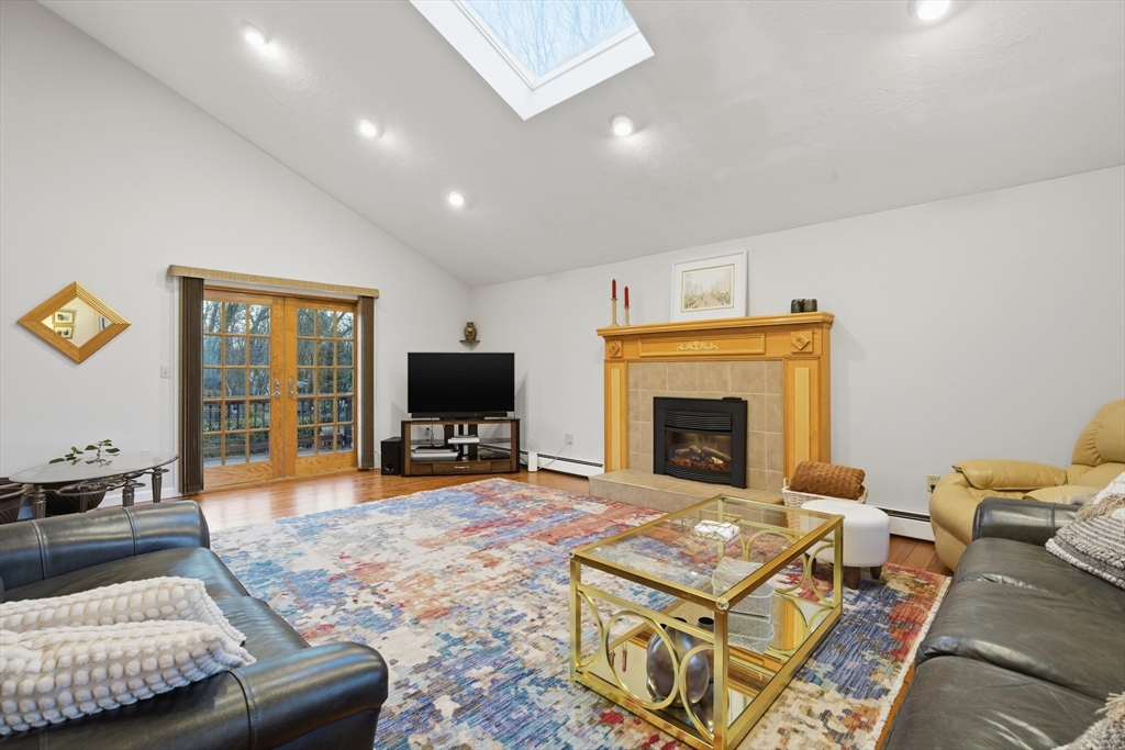 22 Magnolia Road Sharon, MA 02067 - Photo 12 of 42 a living room with furniture a flat screen tv and a fireplace