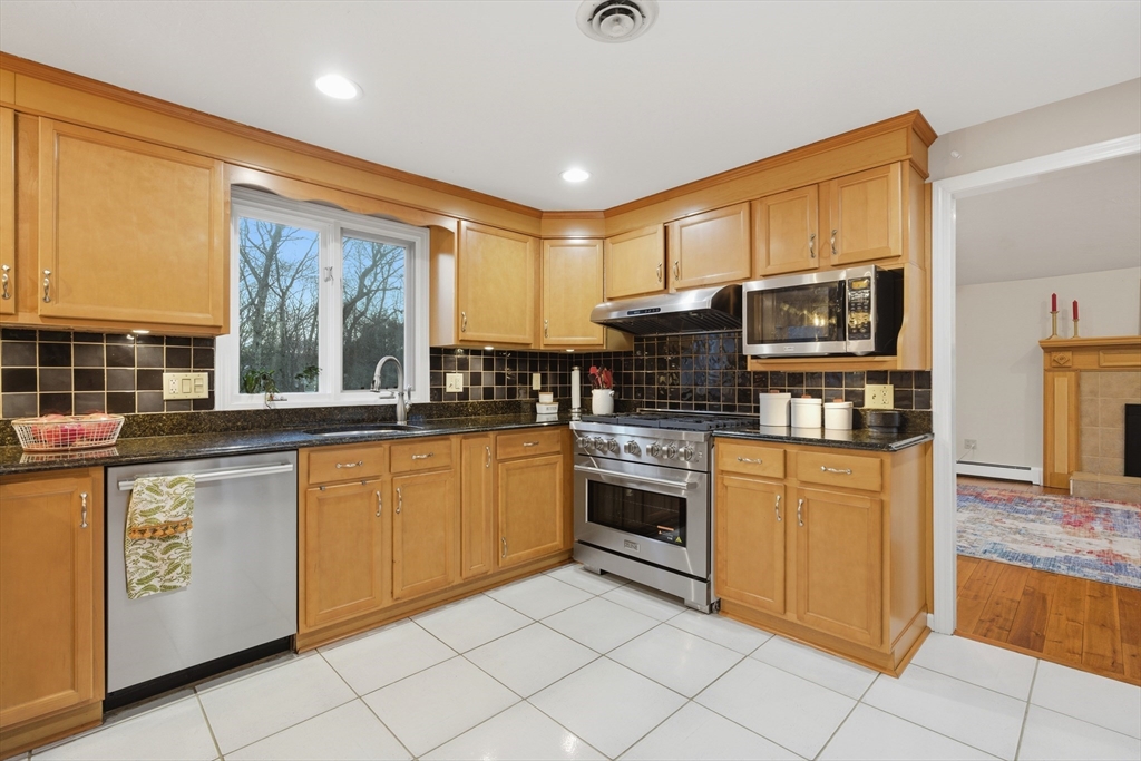 22 Magnolia Road Sharon, MA 02067 - Photo 4 of 42 a kitchen with stainless steel appliances granite countertop a stove top oven microwave and cabinets