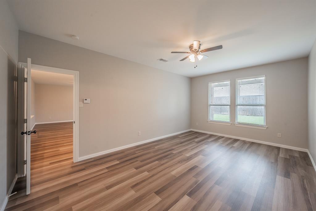 412 Hideaway Road McKinney, TX 75072 - Photo 18 of 40 an empty room with wooden floor ceiling fan and windows