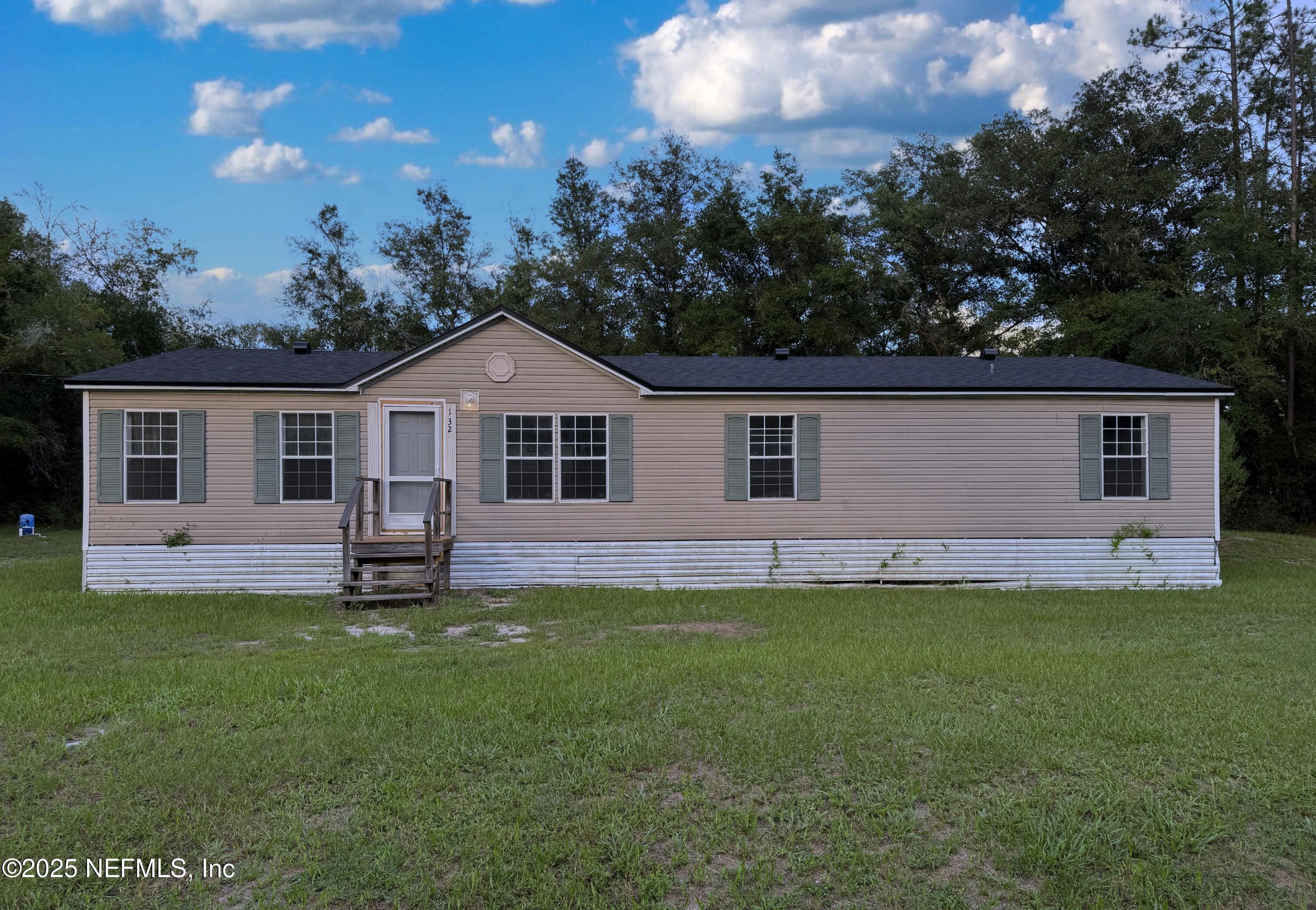 132 Long Road Interlachen, FL 32148 - Photo 1 of 21 a front view of a house with a garden and yard