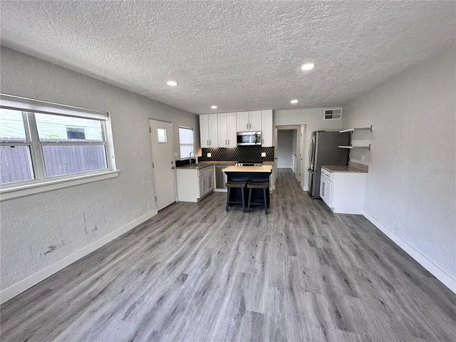 a kitchen with kitchen island wooden floors and appliances