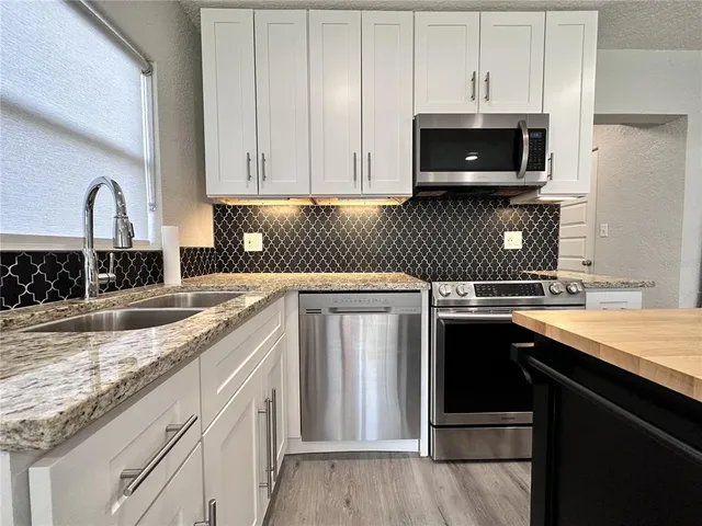 a kitchen with a refrigerator and a stove top oven