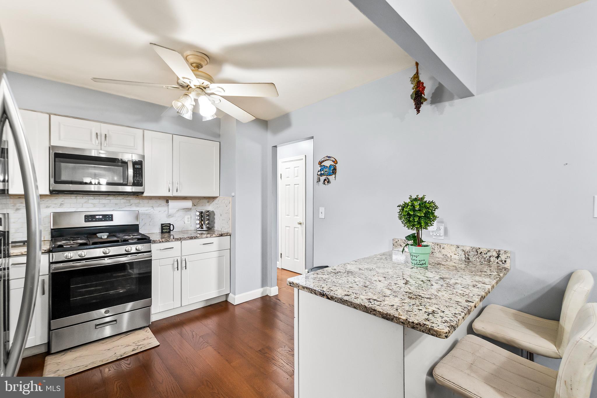 11411 Hermitt Street Clinton, MD 20735 - Photo 11 of 40 a kitchen with stainless steel appliances granite countertop a stove refrigerator and microwave