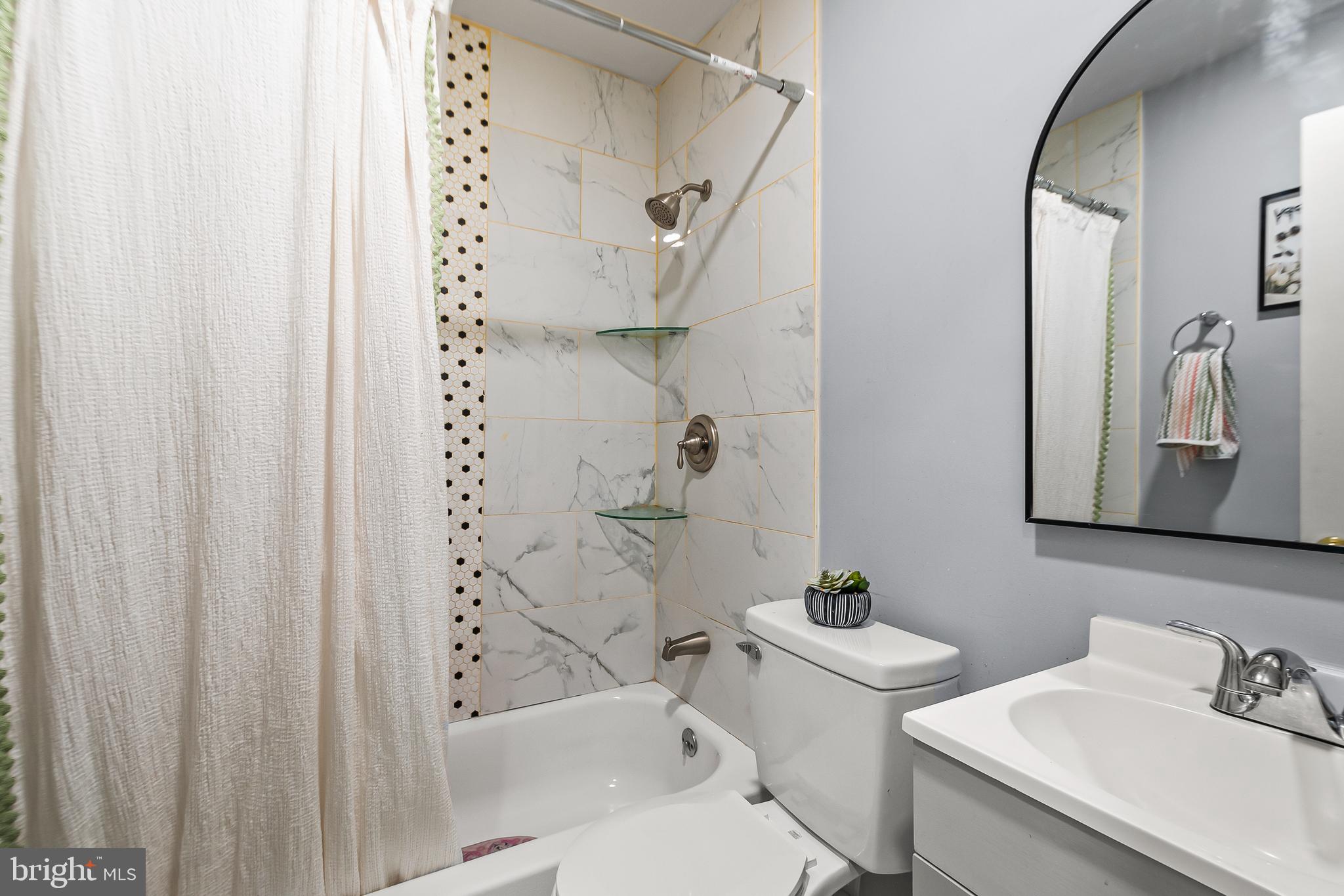 11411 Hermitt Street Clinton, MD 20735 - Photo 15 of 40 a bathroom with a sink a toilet and shower curtain