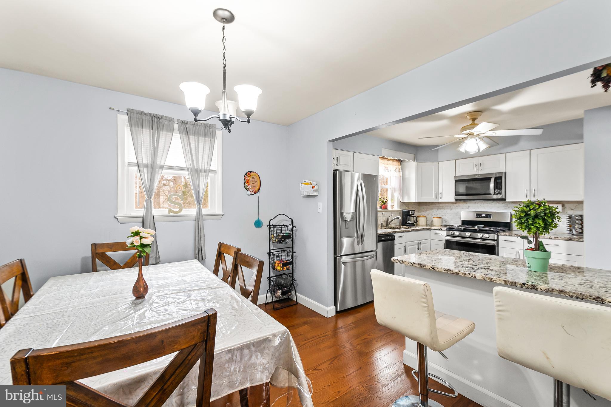 11411 Hermitt Street Clinton, MD 20735 - Photo 10 of 40 a kitchen with stainless steel appliances granite countertop a stove a refrigerator a kitchen island a dining table and chairs